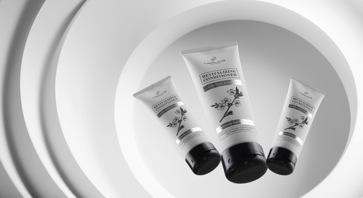 Drei helle Revitalizing Conditioner Tuben schweben vor konzentrischen weißen Ringen