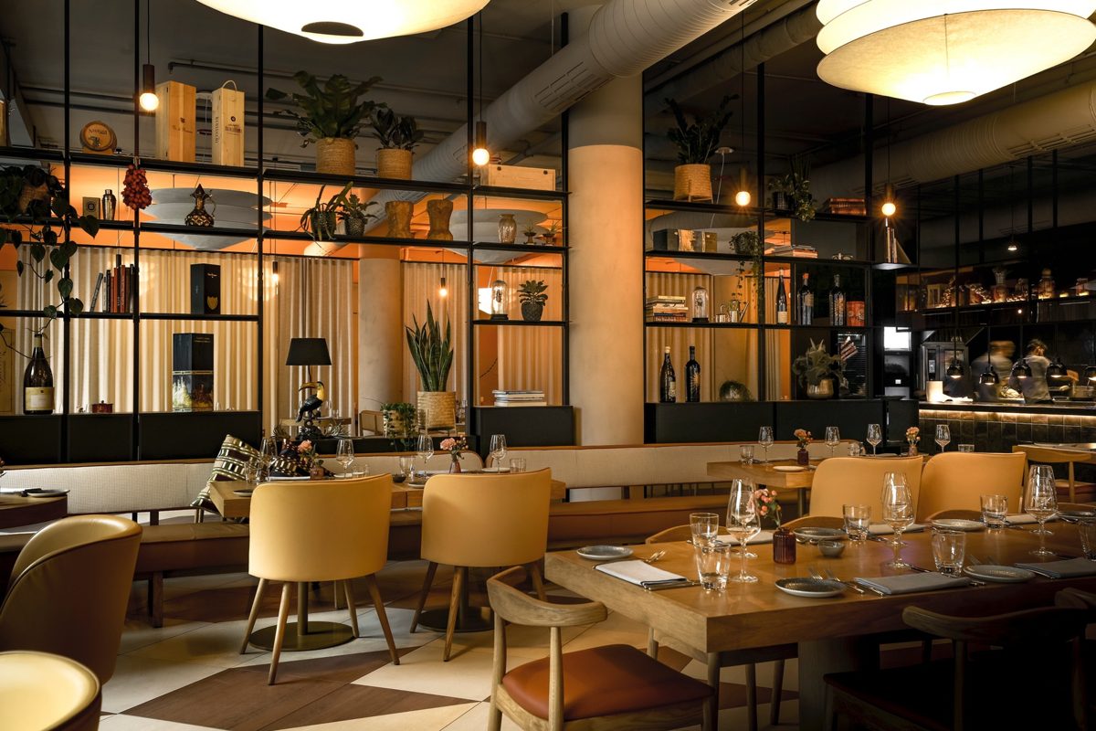 Restaurantbereich mit gelben Polsterstühlen, Holztischen und warmen Kugelleuchten