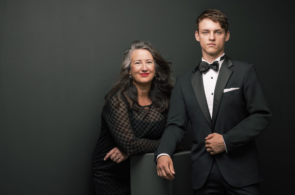 Doppelportrait einer Frau im Spitzenkleid und eines Mannes im Smoking vor dunkelgrüner Wand