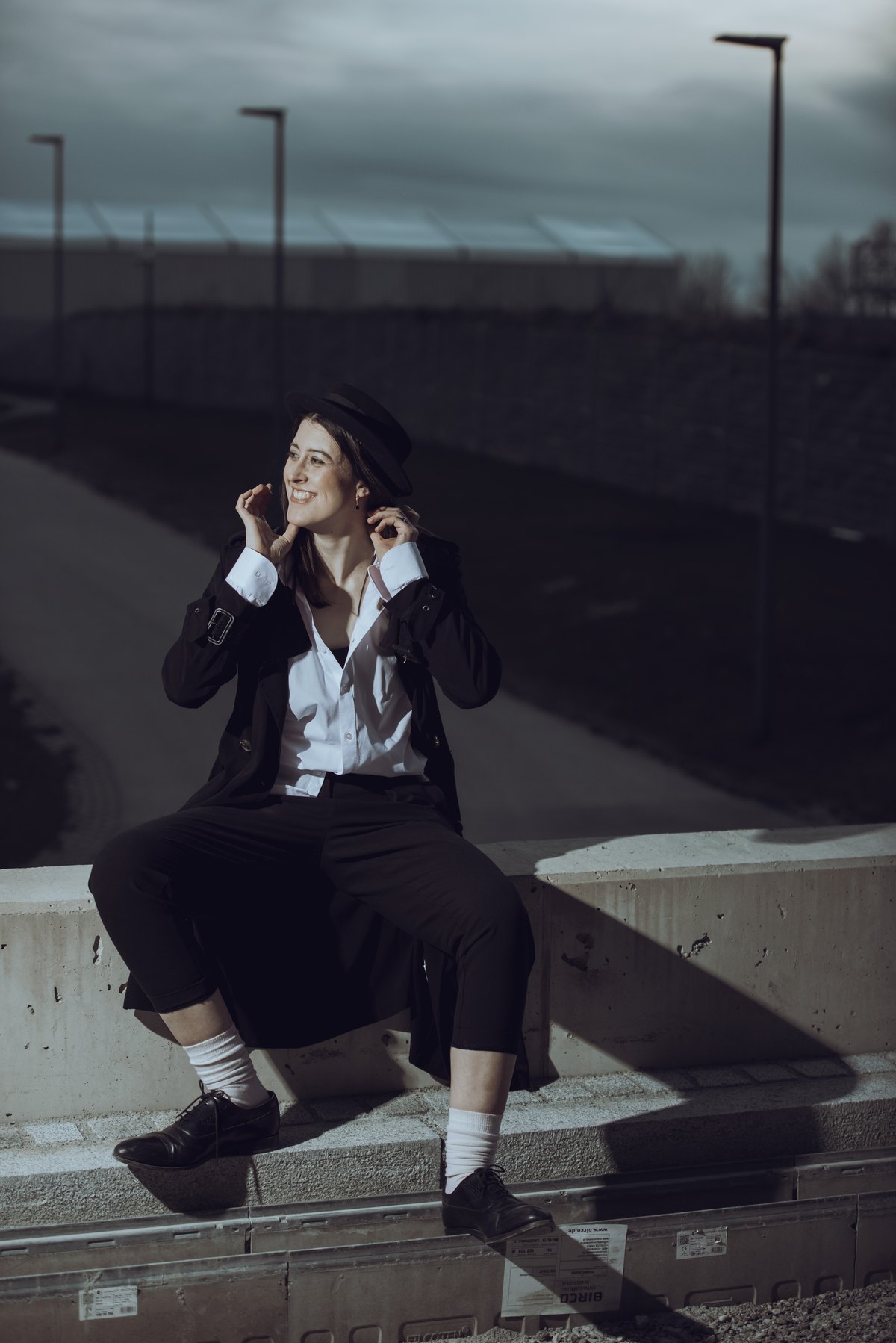 Frau mit Hut auf Betonmauer im Hochformat