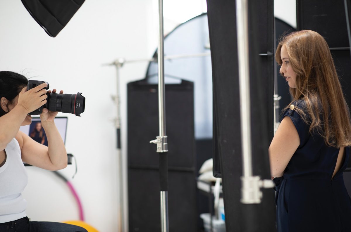 Fotografin beim Porträtshooting einer jungen Frau im Studio hinter den Kulissen