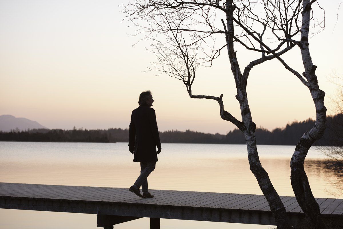 Silhouette einer Person auf einem Steg in der Abenddämmerung