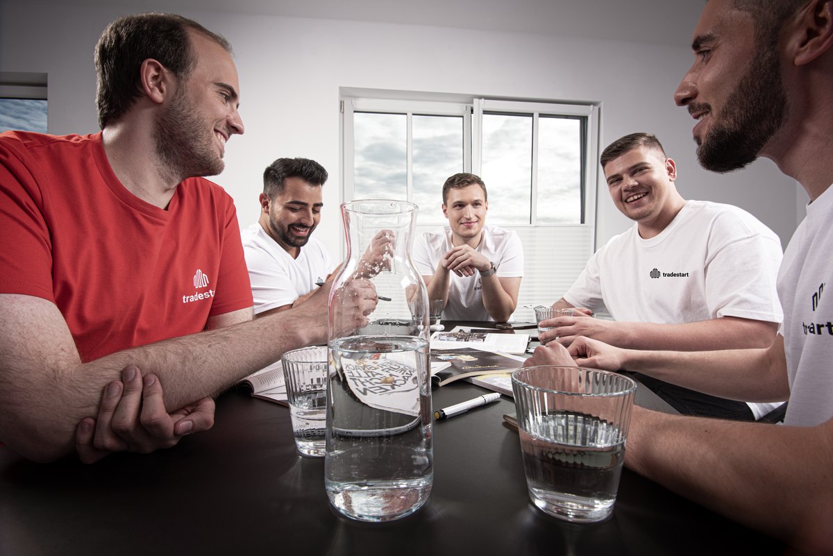 Mitarbeiter in Arbeitskleidung im Gespräch am Tisch
