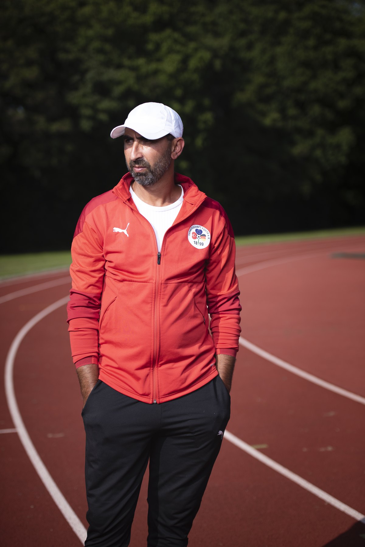 Trainer in roter Jacke auf einer roten Laufbahn