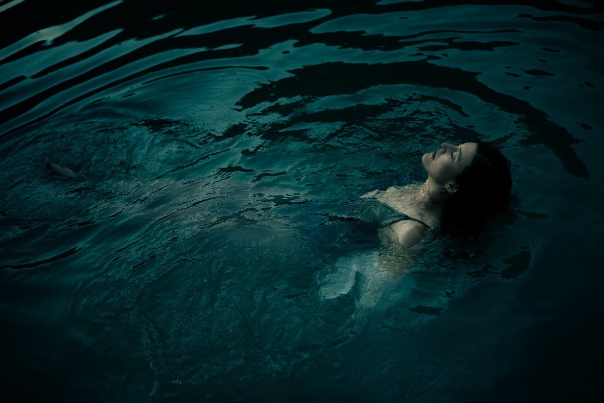 Aufsicht auf eine im Wasser treibende Frau