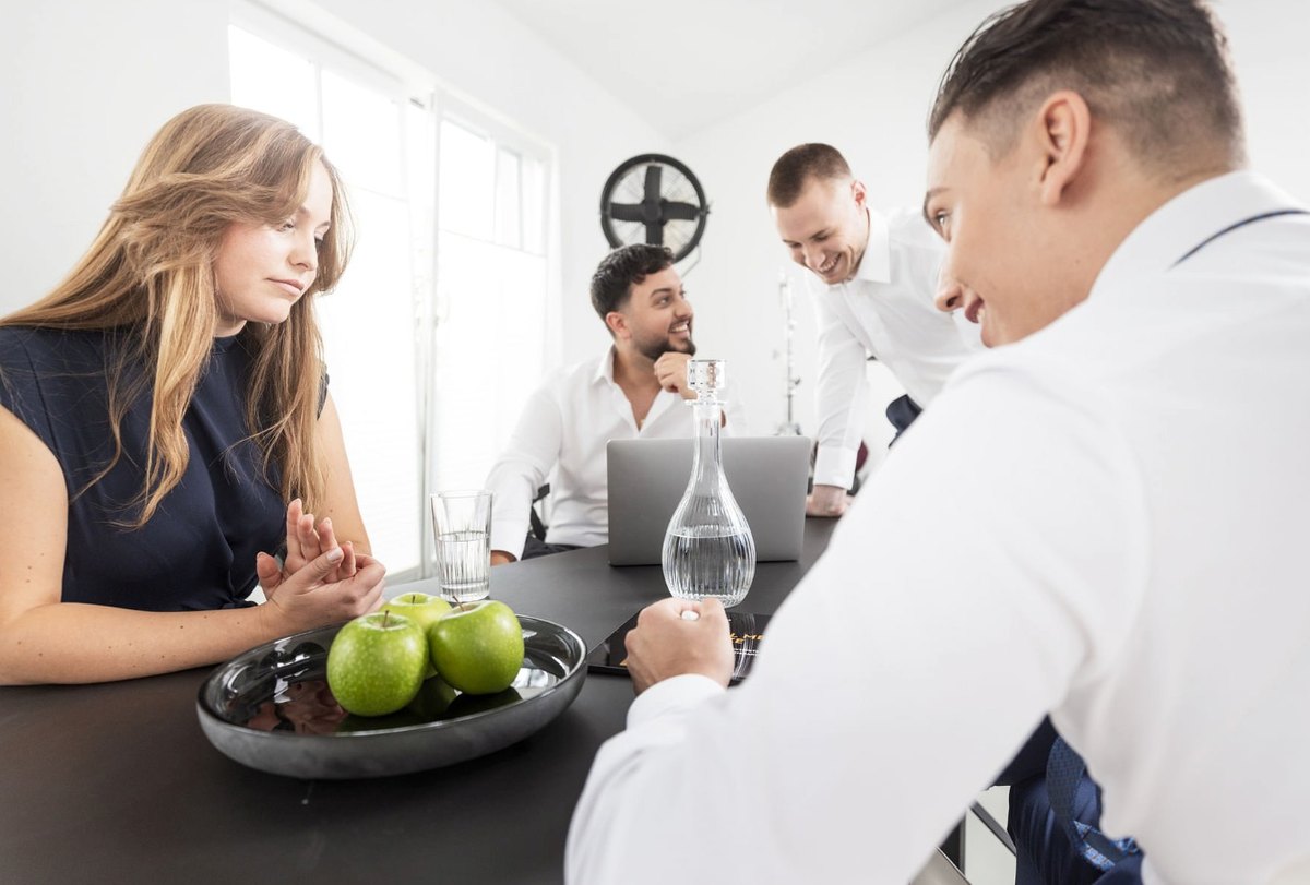 Gruppe von vier Personen im lockeren Gespräch an einem Tisch mit Äpfeln