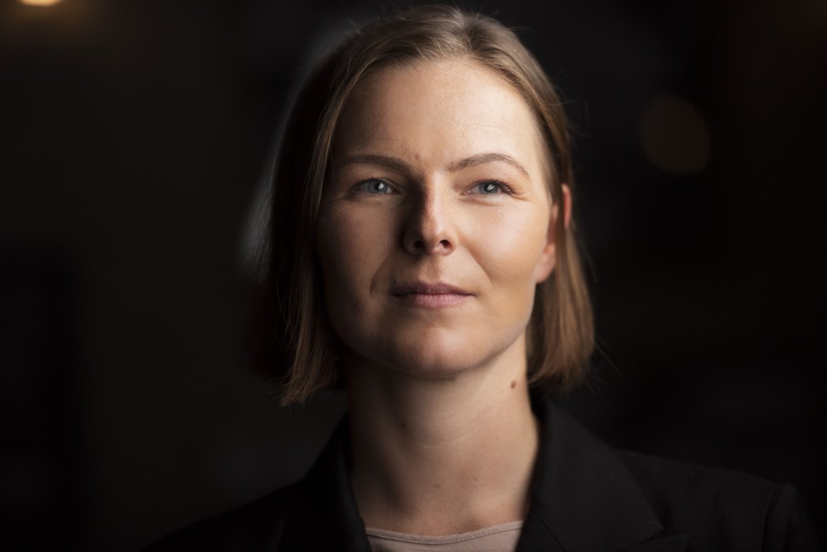 Frau im dunklen Blazer im warmen Low-Key-Licht