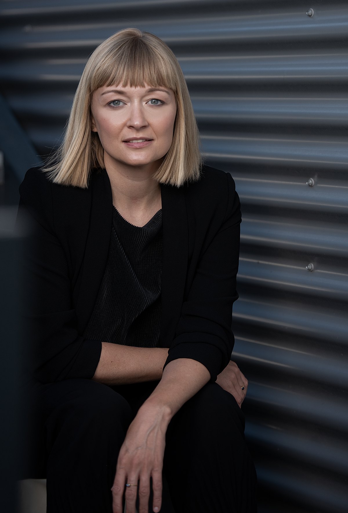 Portrait einer Frau in Schwarz vor gewellter Metallwand