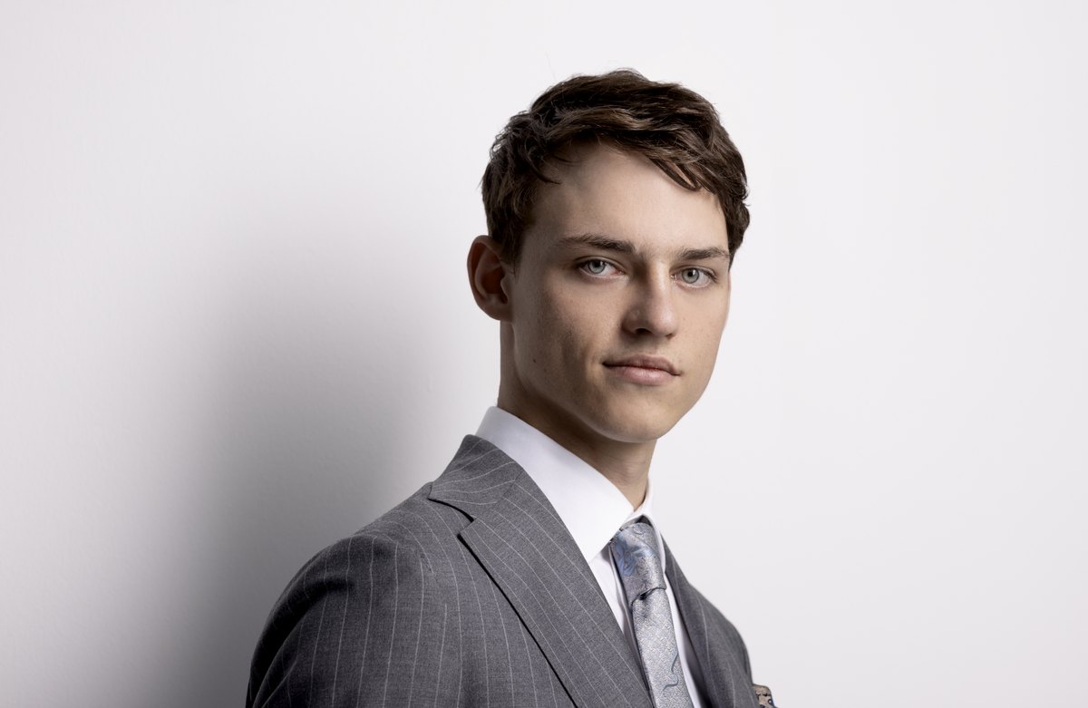 Portrait eines jungen Mannes im grauen Anzug vor hellem Hintergrund