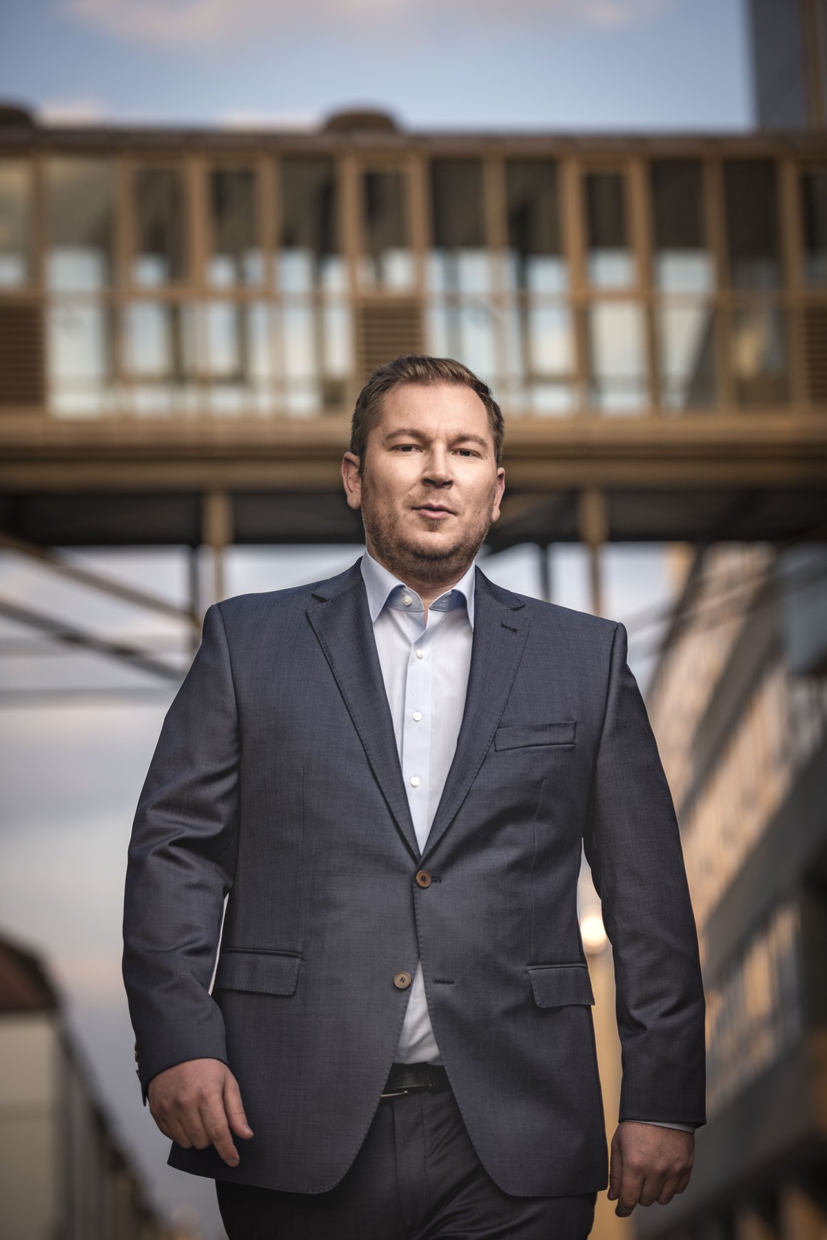 Mann im Anzug vor heller Architekturkulisse