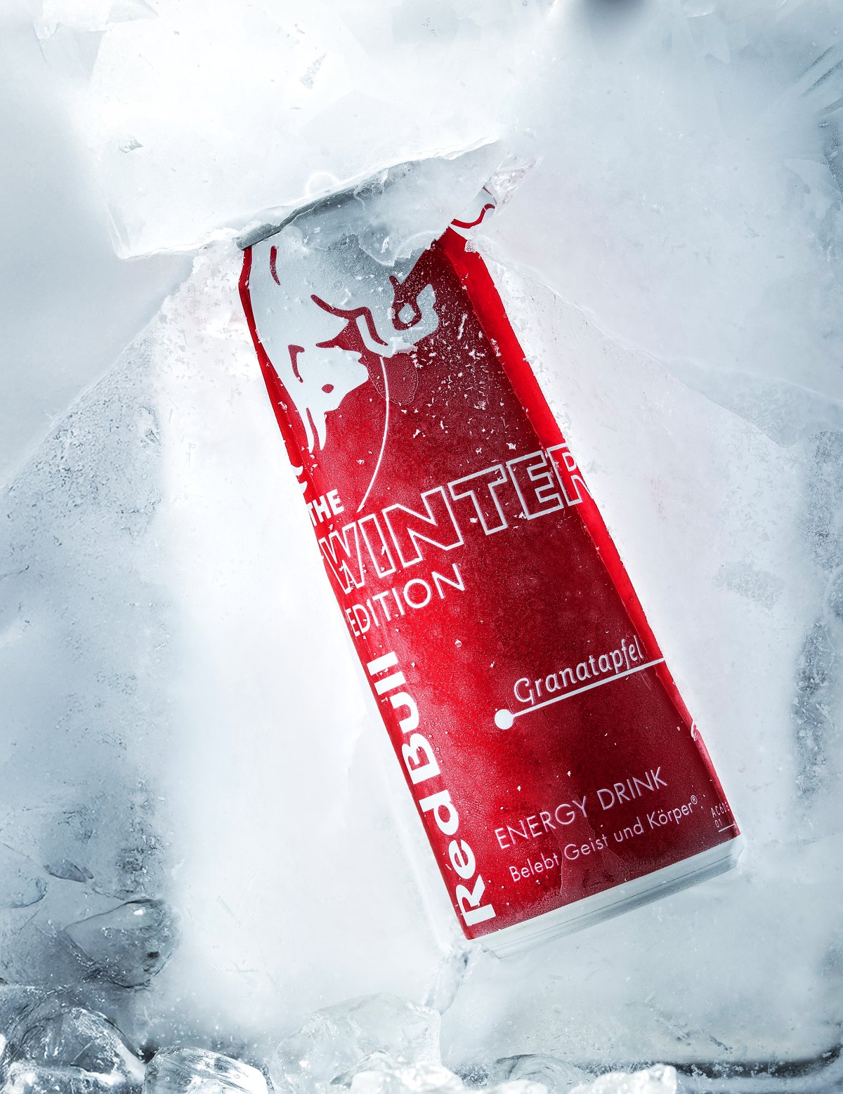 Rote Energydrink-Dose in einem Eisblock vor weißem Hintergrund