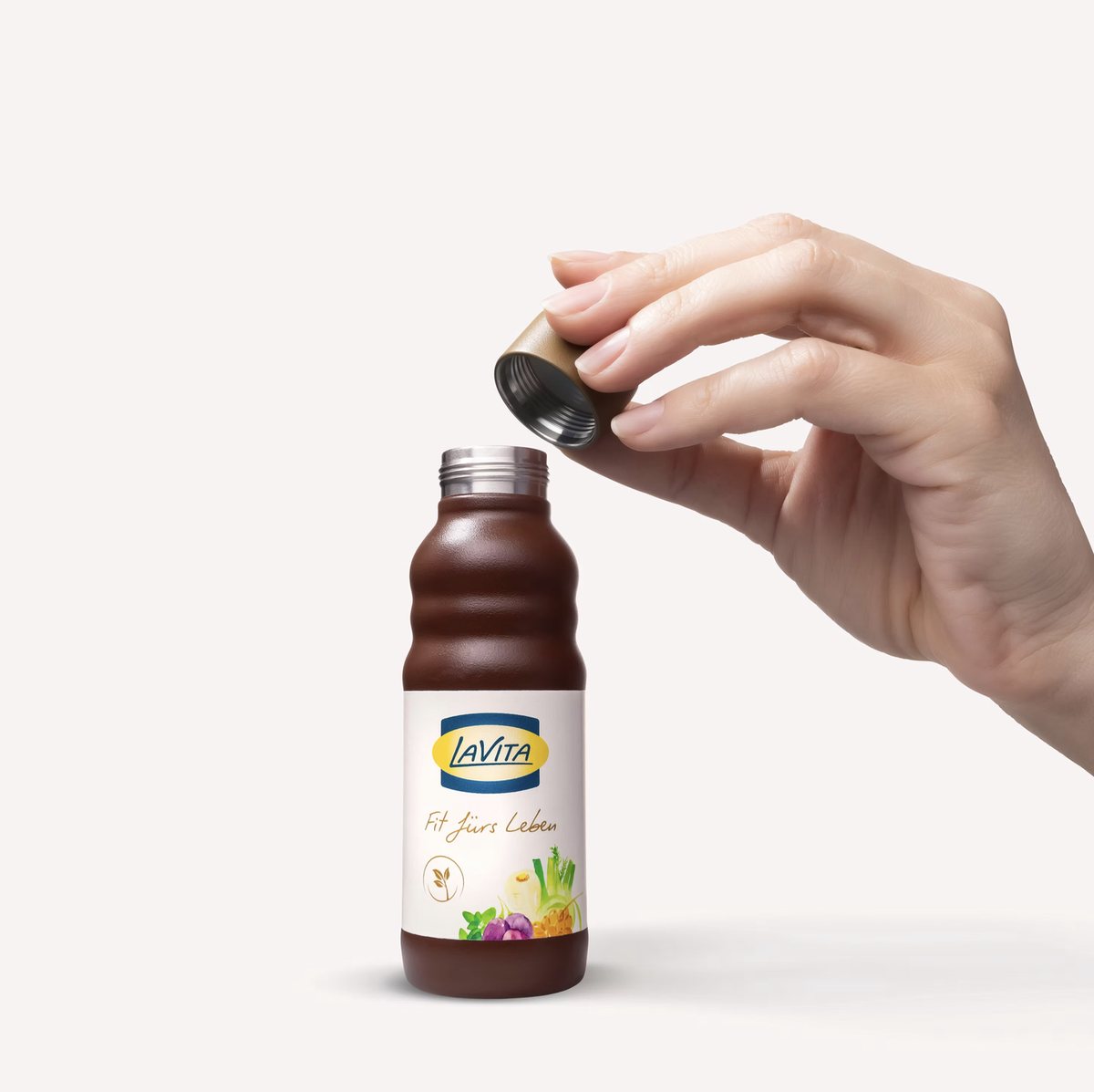 Hand öffnet eine braune Saftflasche vor hellem Hintergrund