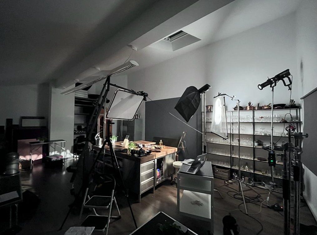Studioraum mit beleuchtetem Aufnahmetisch, Lichtformern und Requisitenregal